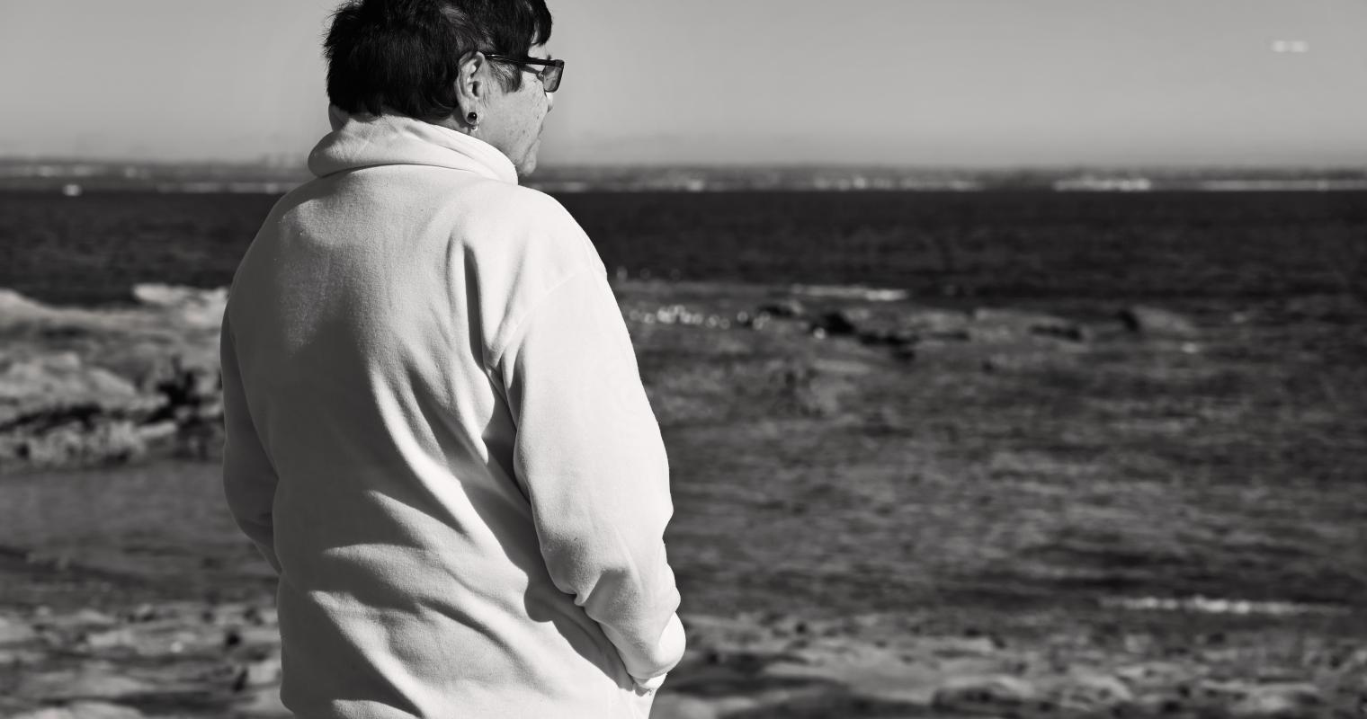 image of a person on the beach looking at water