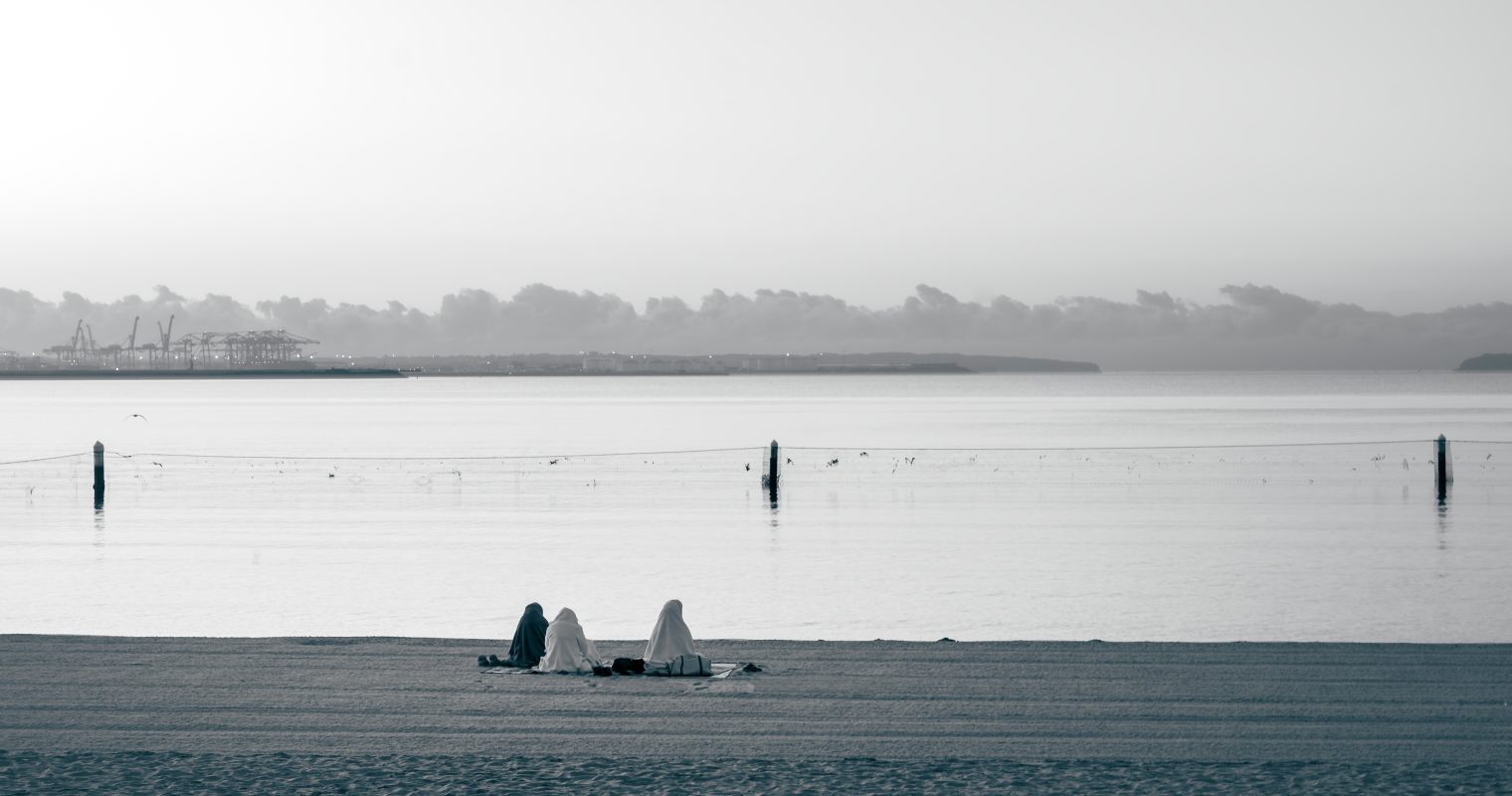 image of three people sitting on the beach