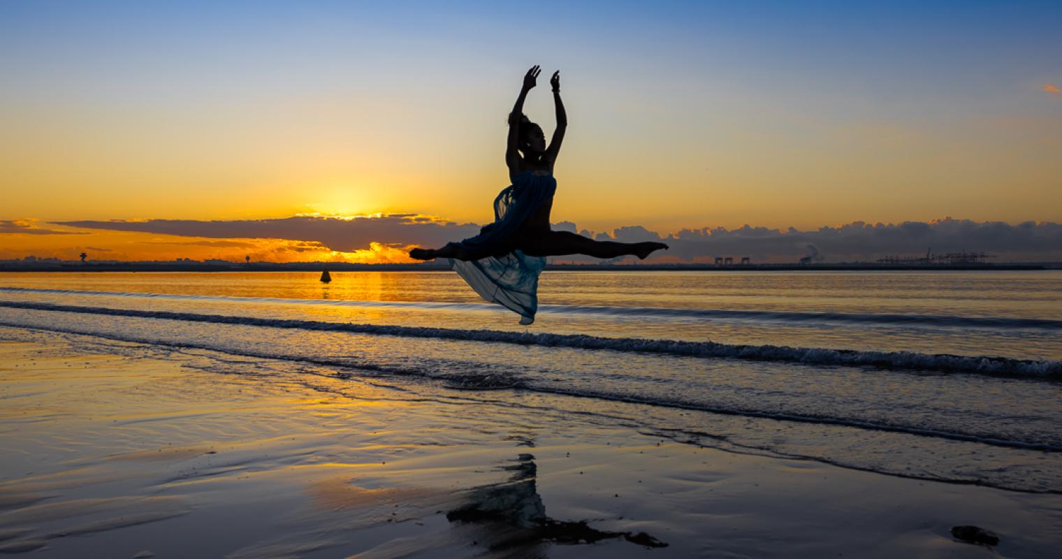 photo of woman jumping in the air at the beach