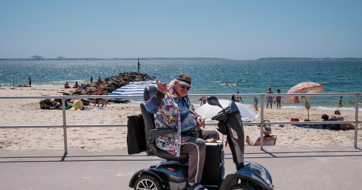 image of a person on a mobility scooter at the beach